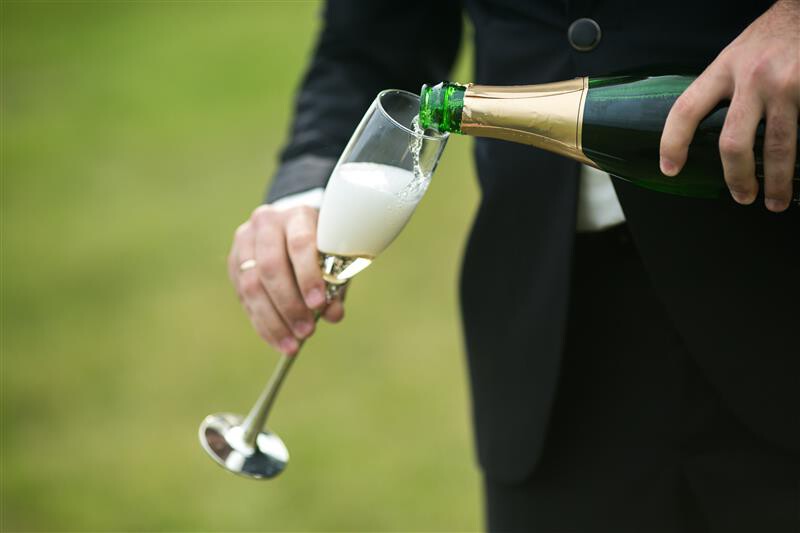 groom-serving-glass-champagne.jpg