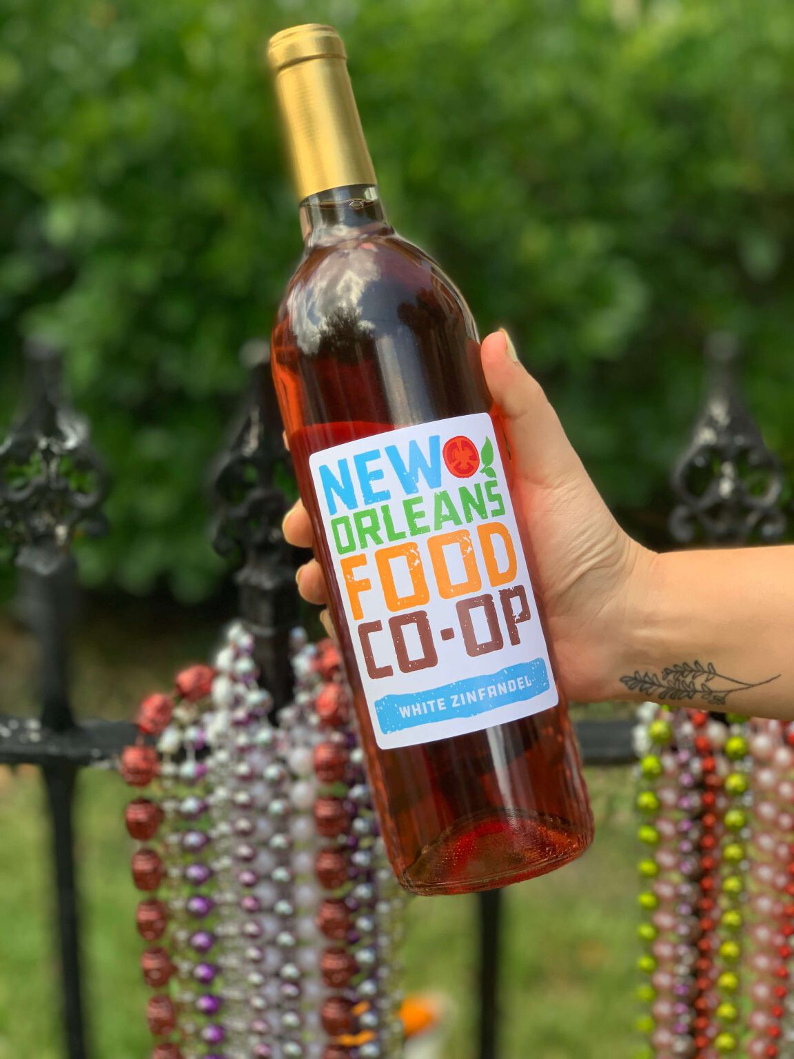 person holding a bottle of new orleans food co-op white zinfandel