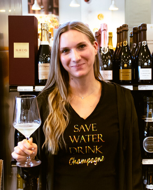 woman smiling holding a glass of white wine